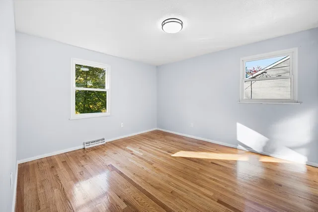 a view of a room with wooden floor and window