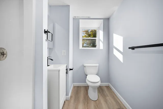 a white toilet sitting next to a bathroom sink and a window