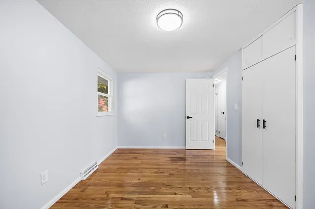 a view of a room with wooden floor and white walls