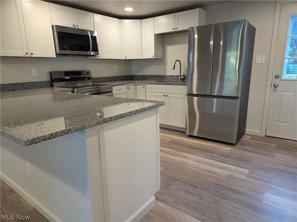 6145 Virginia Road Nashport, OH 43830 - Photo 6 of 24 Kitchen featuring white cabinetry, granite countertops, stainless steel appliances, and wood-finish flooring