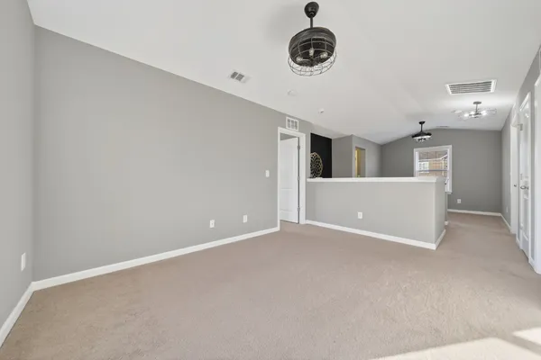 an empty room with a ceiling fan and window