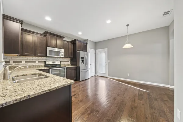 a kitchen with granite countertop stainless steel appliances and wooden cabinets