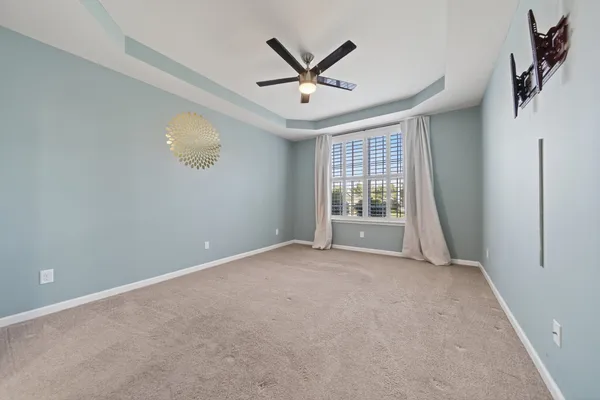 an empty room with windows and ceiling fan