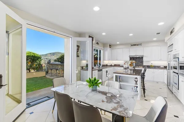 a kitchen with stainless steel appliances granite countertop sink stove and white cabinets with wooden floor