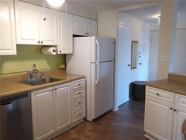 a kitchen with appliances a sink a counter space and cabinets