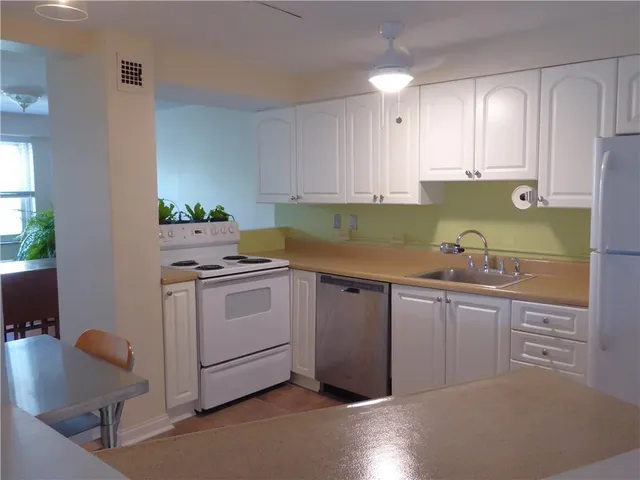 a kitchen with granite countertop white cabinets and white appliances