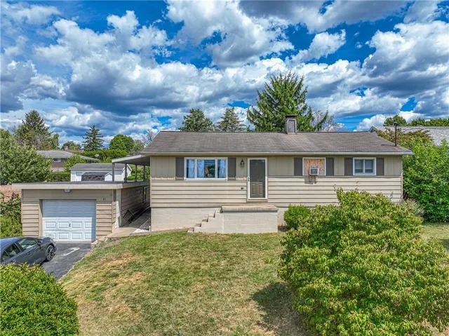 a front view of house with yard and trees around