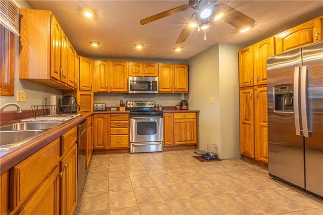 a kitchen with stainless steel appliances granite countertop a sink a stove and a refrigerator