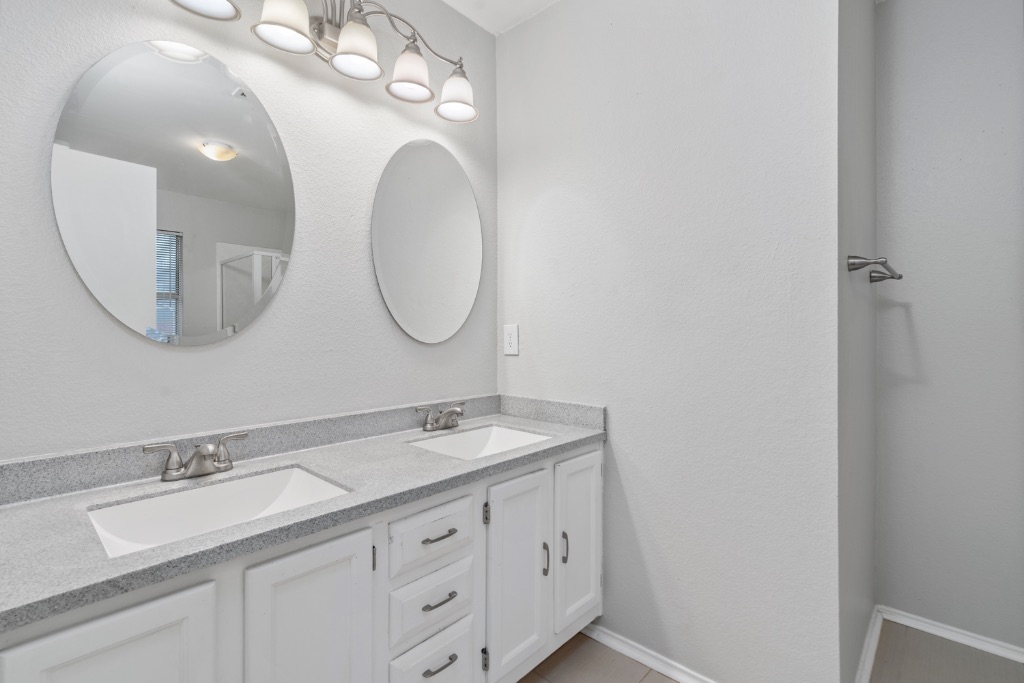 911 Flatters Way Pflugerville, TX 78660 - Photo 16 of 31 a bathroom with a double vanity sink and a mirror