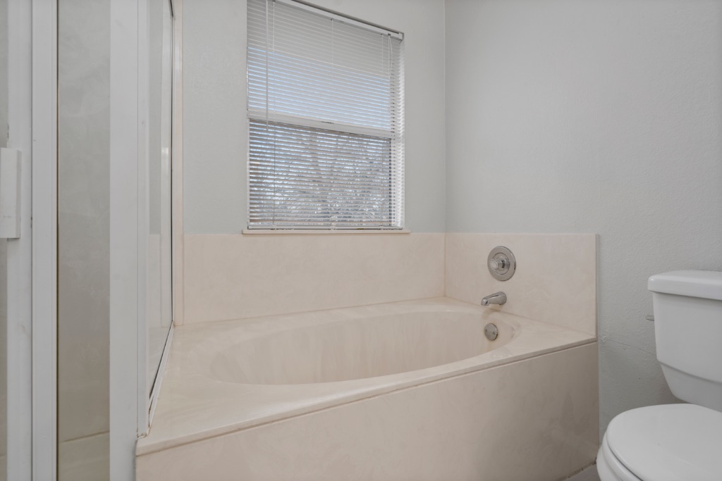 911 Flatters Way Pflugerville, TX 78660 - Photo 18 of 31 a white bath tub sitting next to a toilet