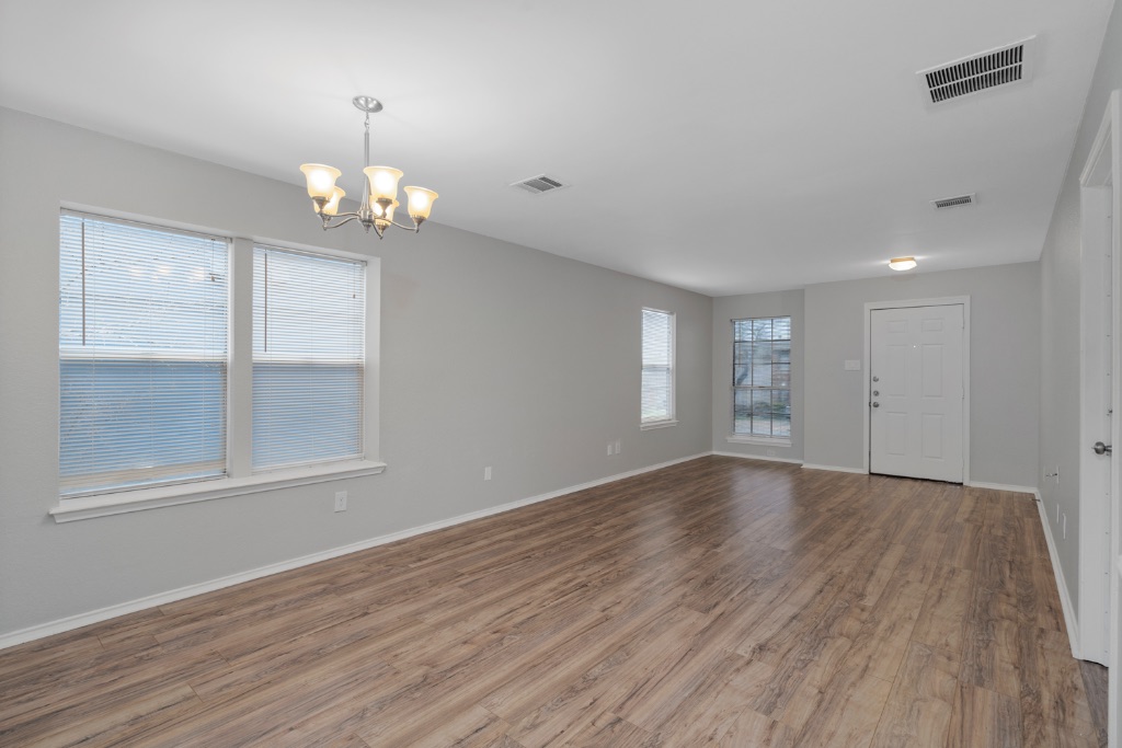 911 Flatters Way Pflugerville, TX 78660 - Photo 6 of 31 an empty room with wooden floor and windows