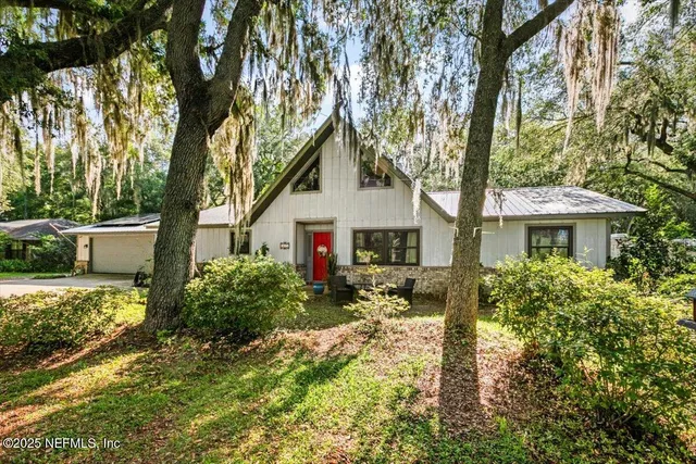a front view of house with yard and trees around