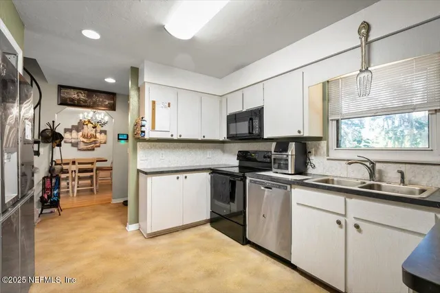 a kitchen with a sink a counter top space stainless steel appliances and cabinets