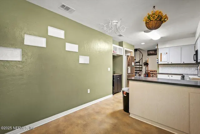 a kitchen with stainless steel appliances granite countertop a sink a stove a refrigerator a washer dryer and a dining table