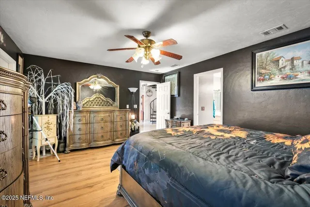 a bedroom with a large bed and a chandelier