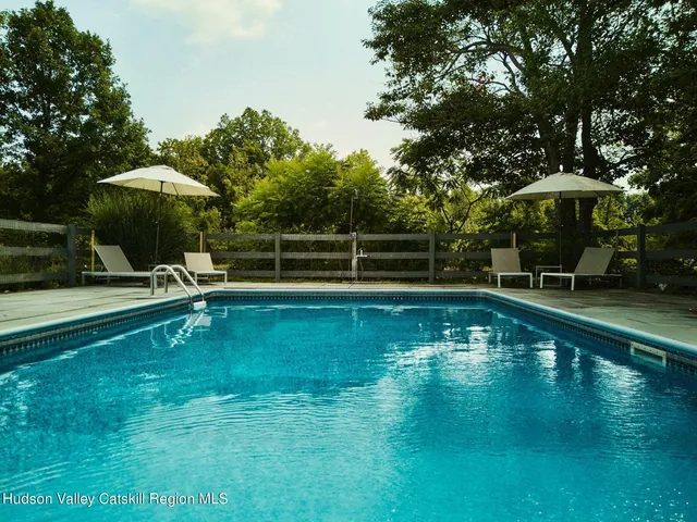 a view of a swimming pool and trees in the background