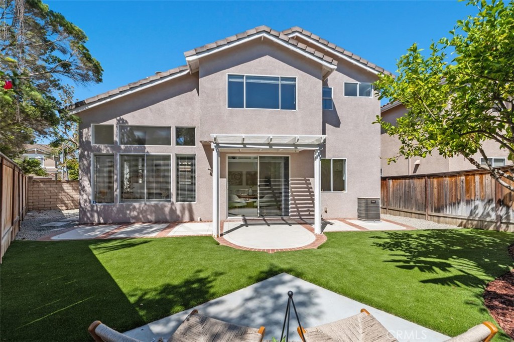 56 Acorn Ridge Rancho Santa Margarita, CA 92688 - Photo 40 of 57 Backyard: Rear exterior view showcases the two-story home, expansive windows, pergola-covered patio, and low-maintenance turf yard.