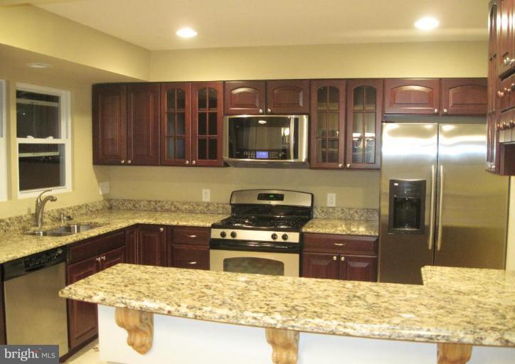 3409 Reedy Drive Annandale, VA 22003 - Photo 9 of 30 a kitchen with stainless steel appliances granite countertop a stove a sink and a microwave