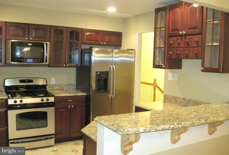 3409 Reedy Drive Annandale, VA 22003 - Photo 10 of 30 a kitchen with stainless steel appliances granite countertop a stove a sink and a refrigerator