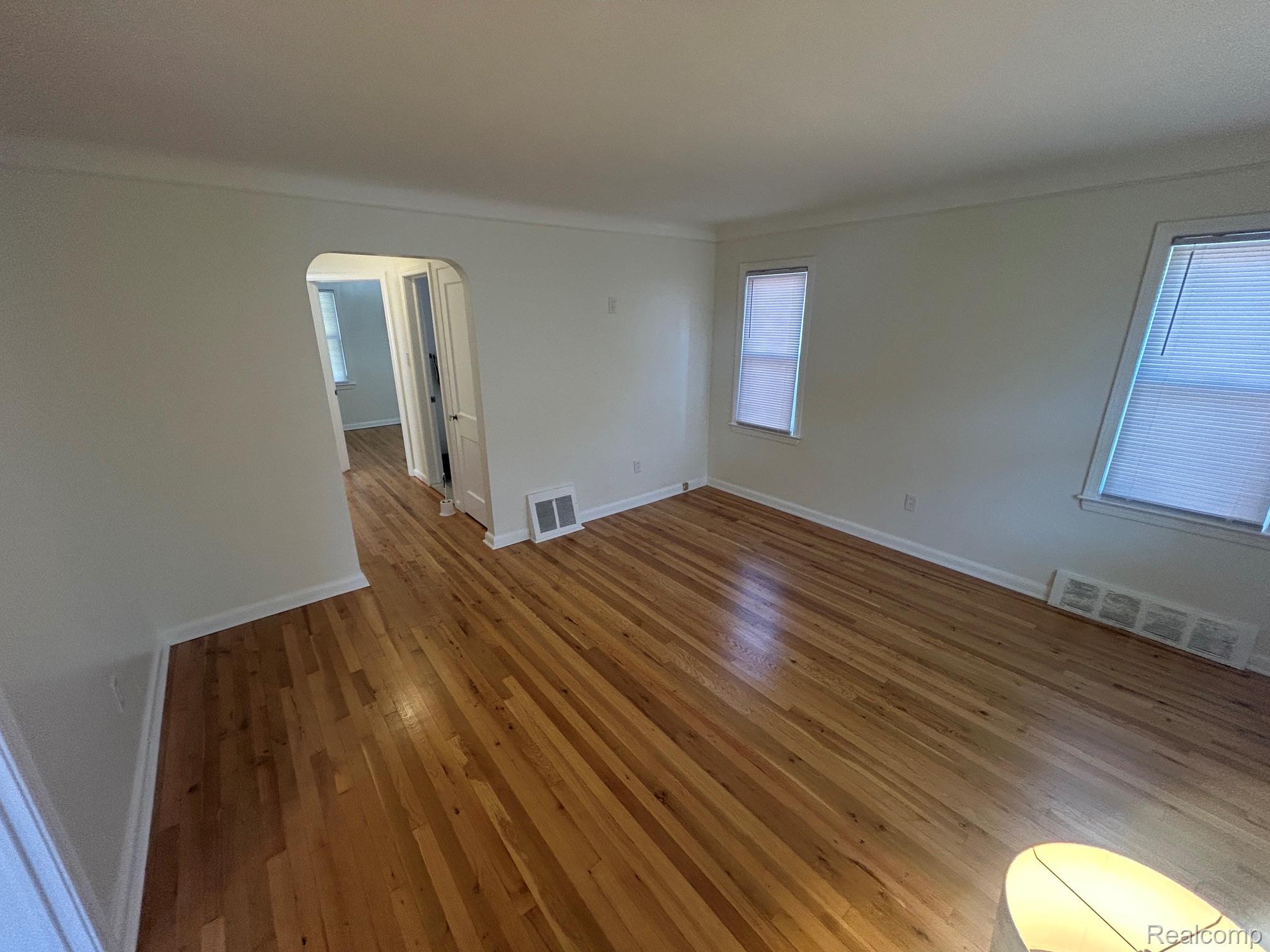 21970 Moross Road Grosse Pointe, MI 48236 - Photo 2 of 21 Hardwood flooring extends throughout this room, featuring light-toned walls and multiple windows