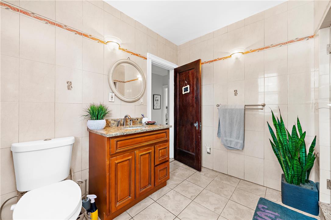 2055 Ferry Street Wilson, PA 18042 - Photo 13 of 21 This clean bathroom features a wood vanity, granite counters, and tiled walls, creating a bright space.