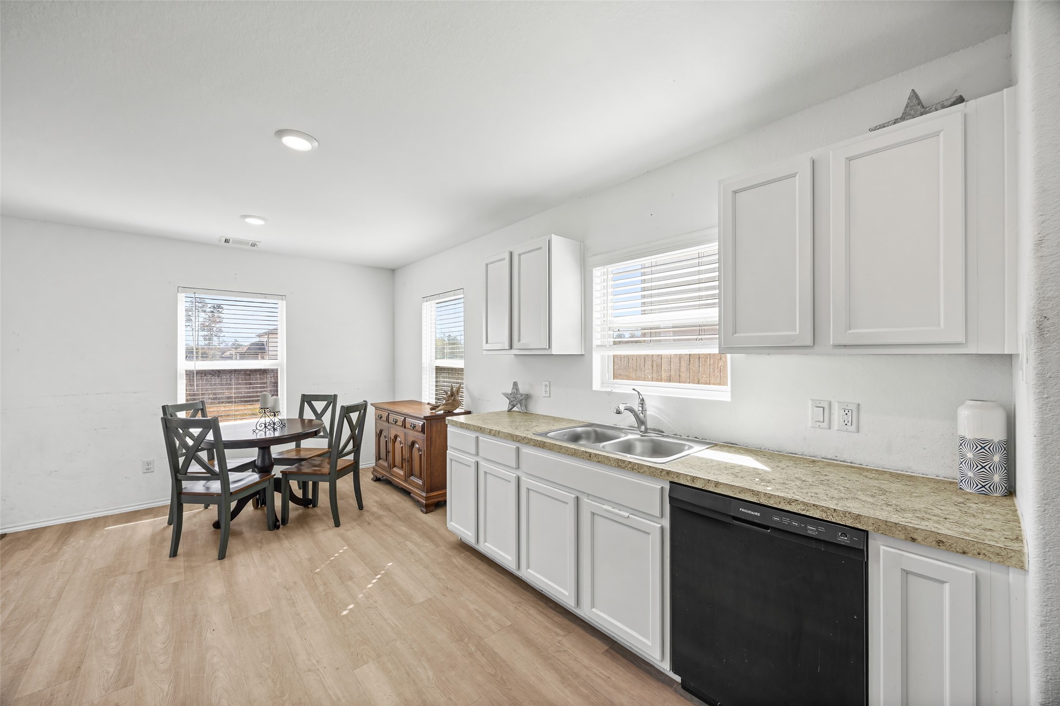 5976 Rimini Landing Lane Porter, TX 77365 - Photo 9 of 18 a kitchen with a dining table chairs and white cabinets