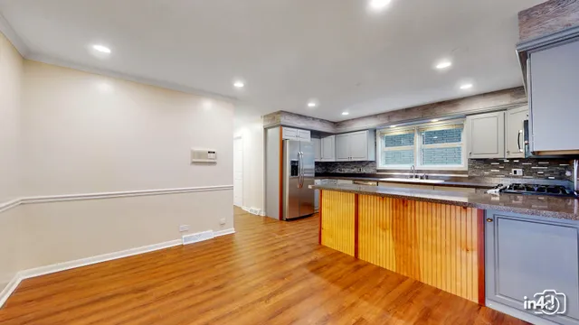 a kitchen with stainless steel appliances granite countertop a refrigerator and a stove top oven