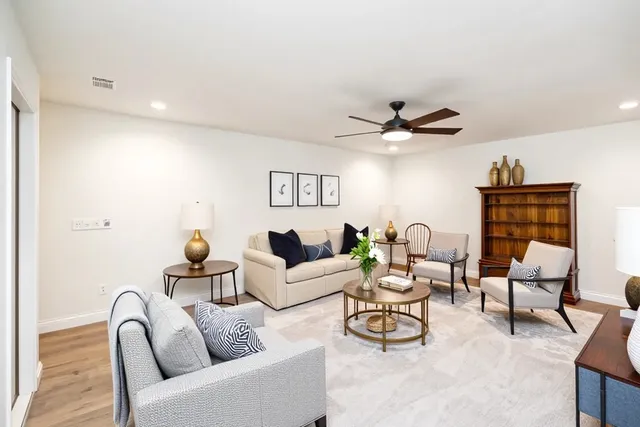 a living room with furniture and a ceiling fan