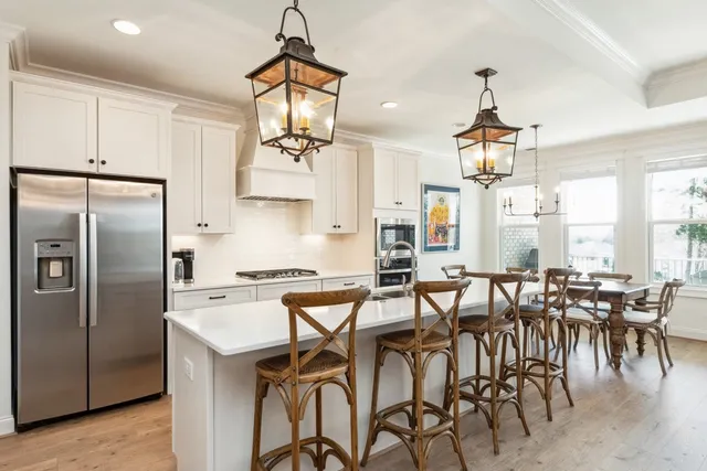 a kitchen with stainless steel appliances a table chairs and chandelier