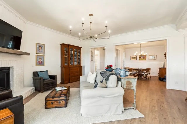 a living room with furniture a flat screen tv and kitchen view