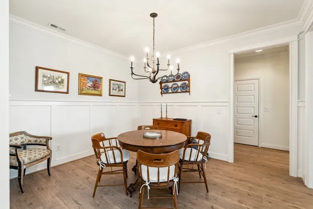 a view of a dining room with furniture wooden floor and chandelier