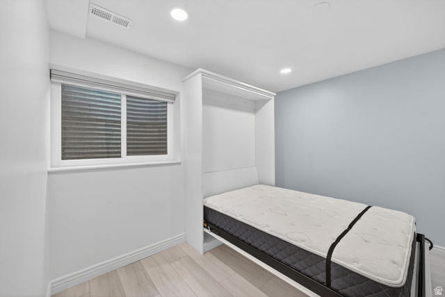 6969 South 855 East Midvale, UT 84047 - Photo 12 of 55 Built-in wall bed frame with accompanying cabinetry, light wood-finish flooring, recessed ceiling lighting, and a window with blinds