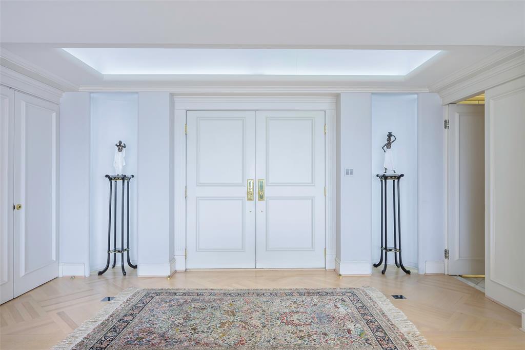 an empty room with a mirror and a wooden door