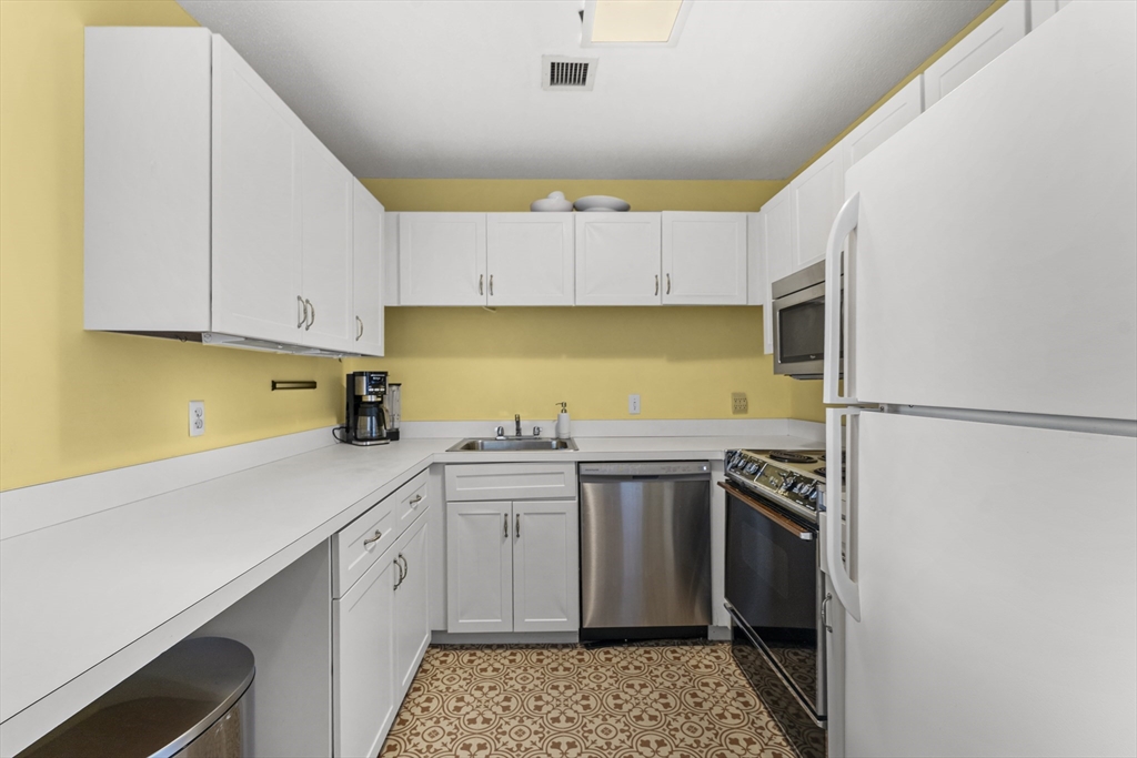 51 Pettee Street, Unit 31 Newton, MA 02464 - Photo 5 of 15 a kitchen with stainless steel appliances a sink stove and refrigerator