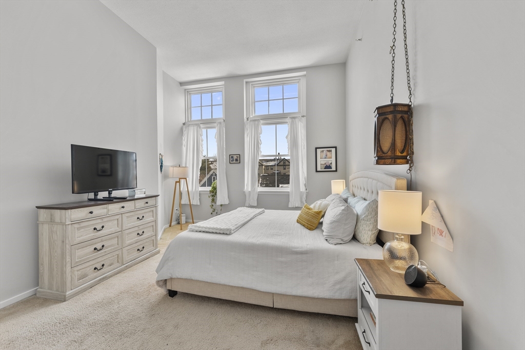 51 Pettee Street, Unit 31 Newton, MA 02464 - Photo 9 of 15 a bedroom with a bed and flat screen tv