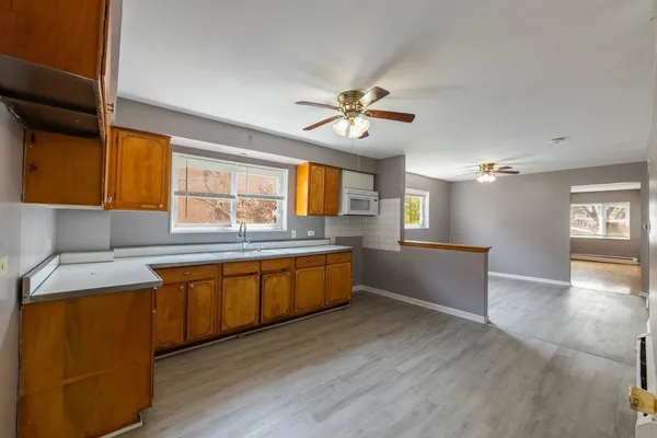 a large kitchen with stainless steel appliances granite countertop a sink a stove and wooden floors