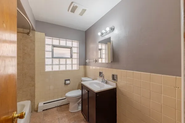 a bathroom with a toilet sink and mirror