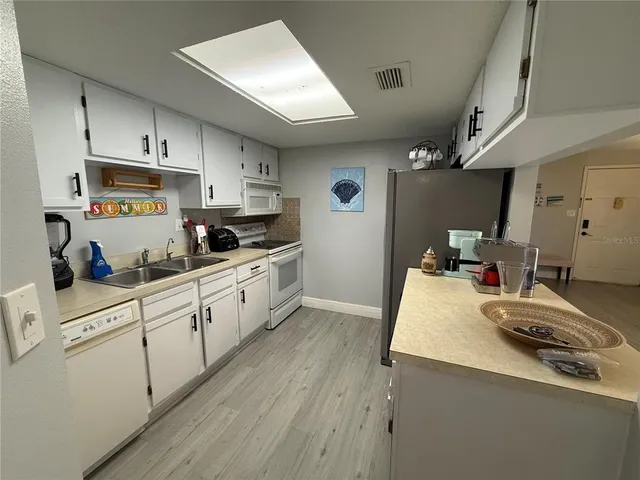 a kitchen with a sink a stove and cabinets