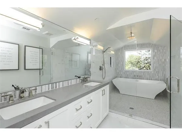 a bathroom with a granite countertop sink mirror and bathtub