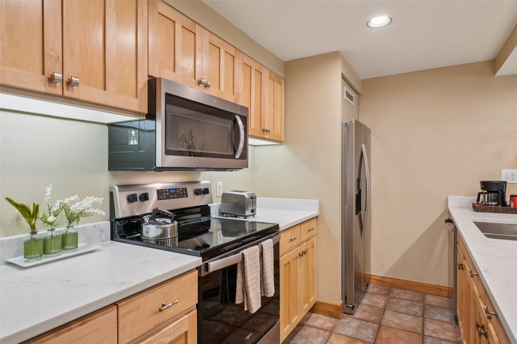 22097 Saints John Road, Unit 2506 Keystone, CO 80435 - Photo 13 of 47 Kitchen featuring stainless steel appliances, light brown cabinetry, light stone counters, and recessed lighting