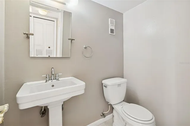 a bathroom with a toilet a sink and mirror