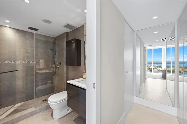 a bathroom with a toilet shower vanity and a sink