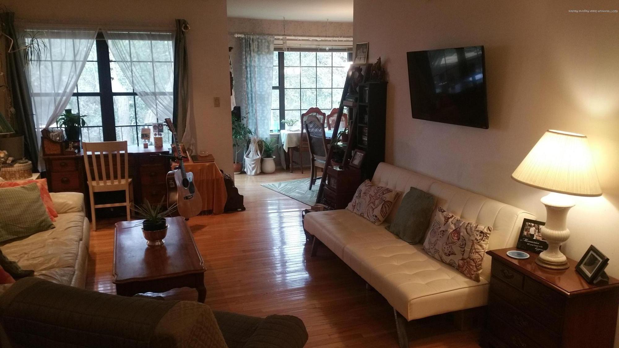 200 Portland Road, Unit C6 Highlands, NJ 07732 - Photo 5 of 19 a living room with furniture a flat screen tv and floor to ceiling windows