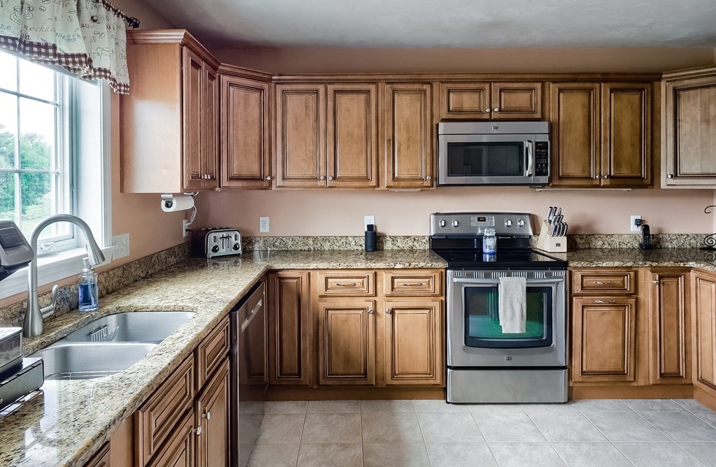 245 Pleasantdale Road Rutland, MA 01543 - Photo 3 of 24 a kitchen with granite countertop a sink stainless steel appliances and cabinets
