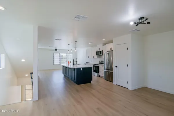 a large kitchen with cabinets wooden floor and stainless steel appliances