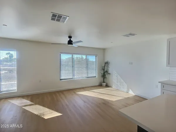 a large white kitchen with wooden floors and stainless steel appliances