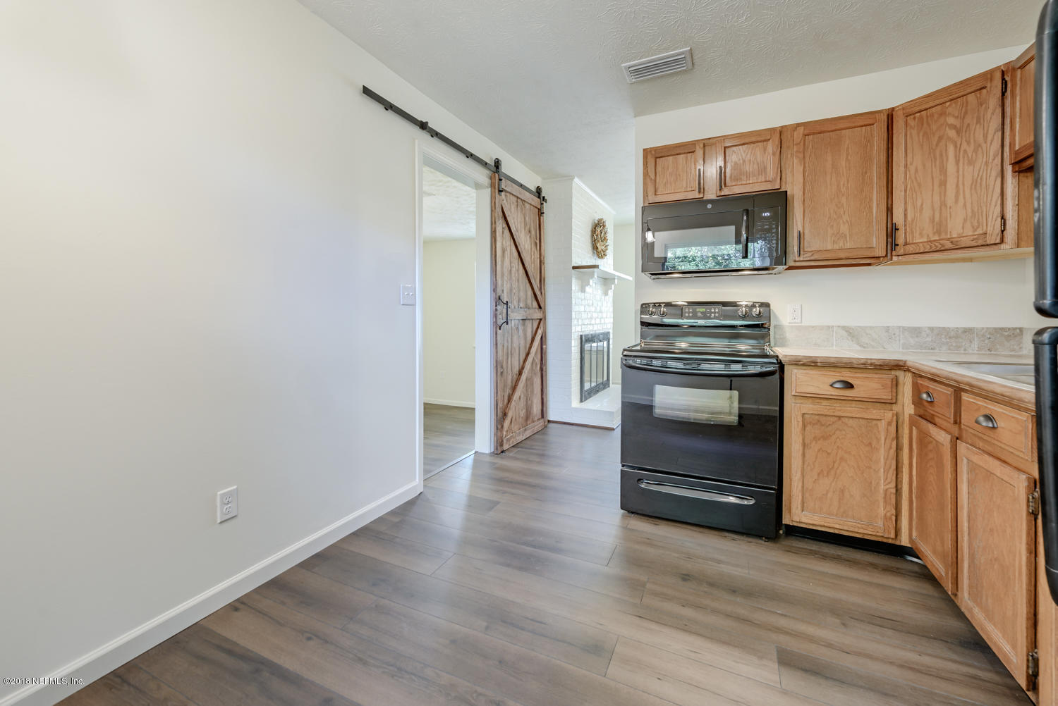 117 Tanager Road St. Augustine, FL 32086 - Photo 11 of 30 a kitchen with white cabinets and stainless steel appliances