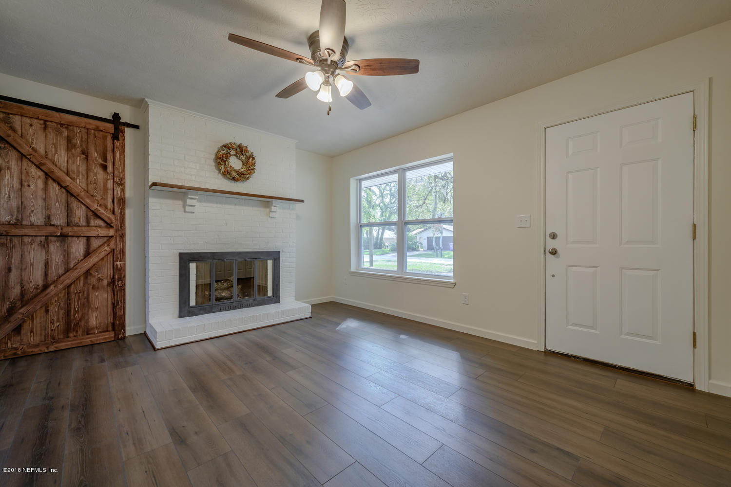 117 Tanager Road St. Augustine, FL 32086 - Photo 5 of 30 an empty room with windows fireplace and wooden floor