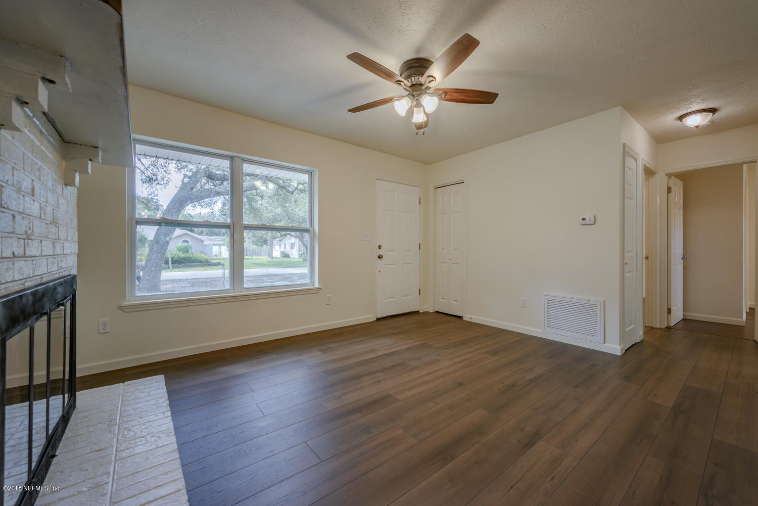 117 Tanager Road St. Augustine, FL 32086 - Photo 6 of 30 an empty room with wooden floor chandelier fan and windows