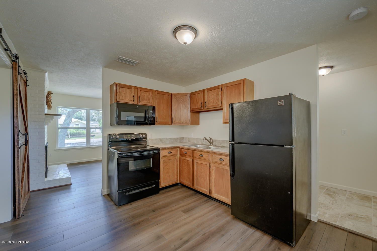 117 Tanager Road St. Augustine, FL 32086 - Photo 8 of 30 a kitchen with a refrigerator and a stove top oven